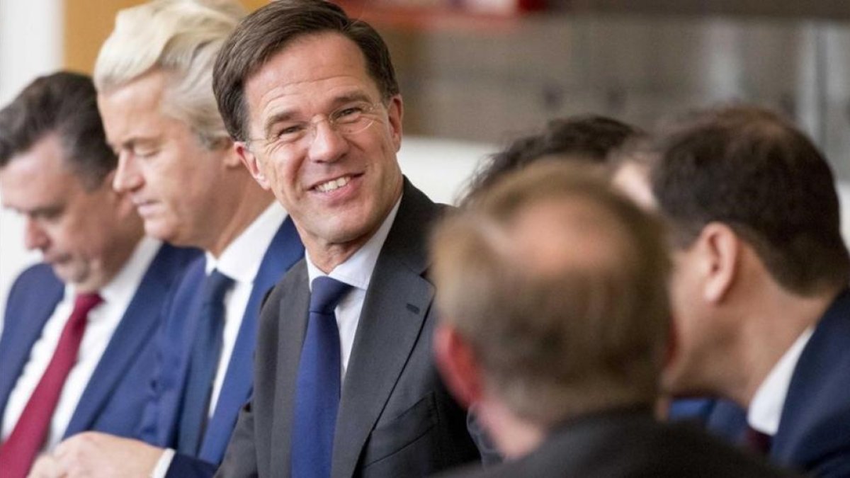 Rutte (sonriente en el centro) y Wilders (segundo izquierda), durante una reunión en La Haya, el 16 de marzo.-EFE / JERRY LAMPEN