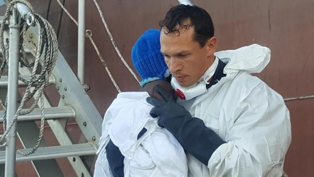 Un guardacostas italiano sostiene a la pequeña Favour en Lampedusa.-AFP