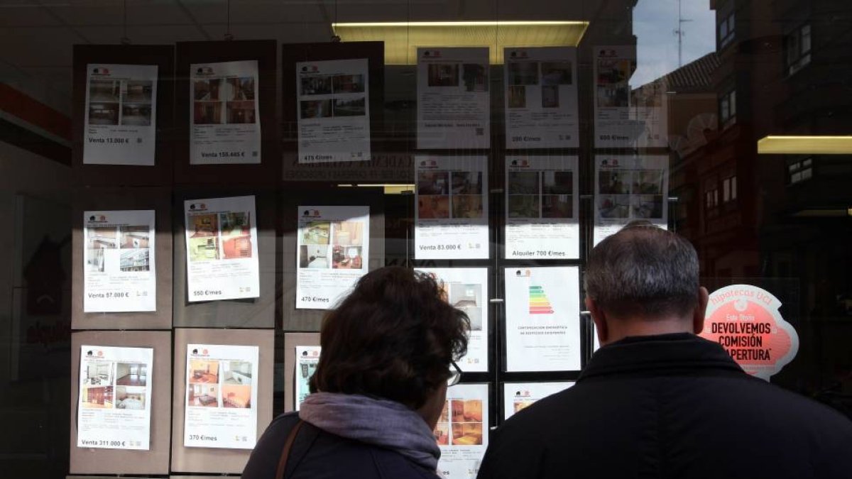 Una pareja mira los anuncios de una inmobiliaria en Valladolid-Ical