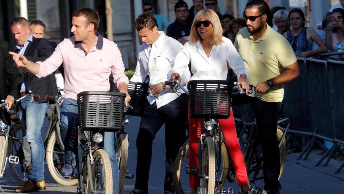 El presidente Macron y su esposa, Brigitte, dan un paseo en bicicleta, el pasado miércoles en Le Touquet.-EL PERIÓDICO