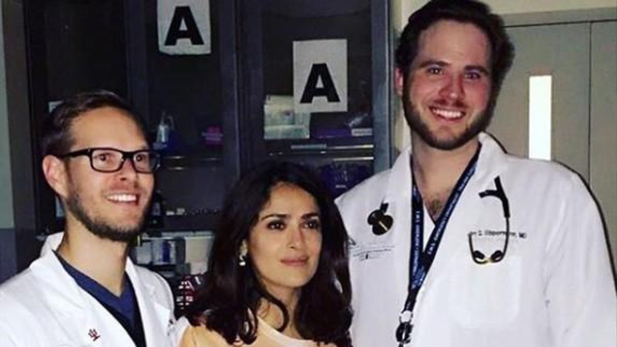 Salma Hayek, con la camiseta que representa unas manos cogiéndole los pechos, posa con los doctores que la han atendido de urgencia en el hospital.-INSTAGRAM