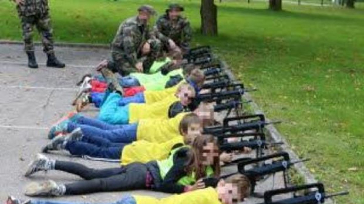 Los niños tirados en el suelo con fusiles de asalto.-