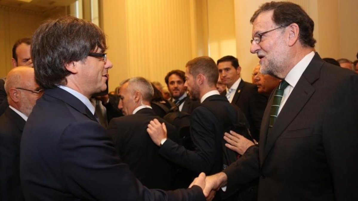 Puigdemont y Rajoy se saludan en el acto de inauguración de una exposición sobre Joan Miró en Oporto el pasado mes de septiembre-EL PERIÓDICO