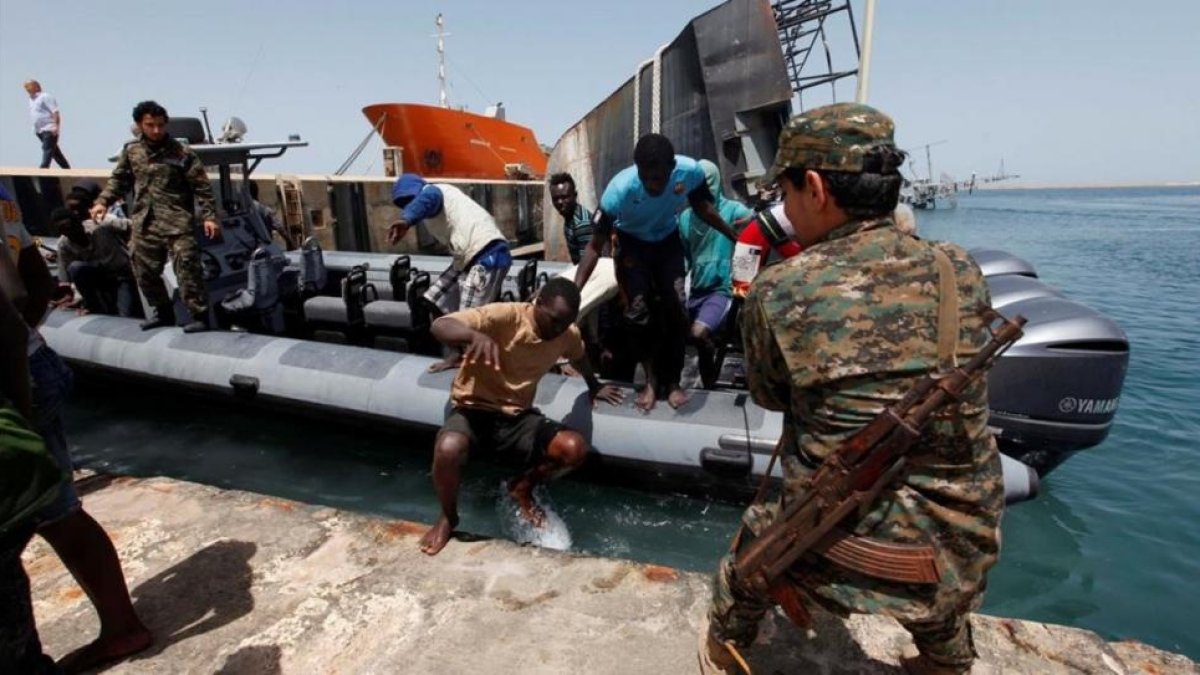Inmigrantes llegan a la base naval libia después de haber sido rescatados por guardacostas libios en la costa de Trípoli.-REUTERS