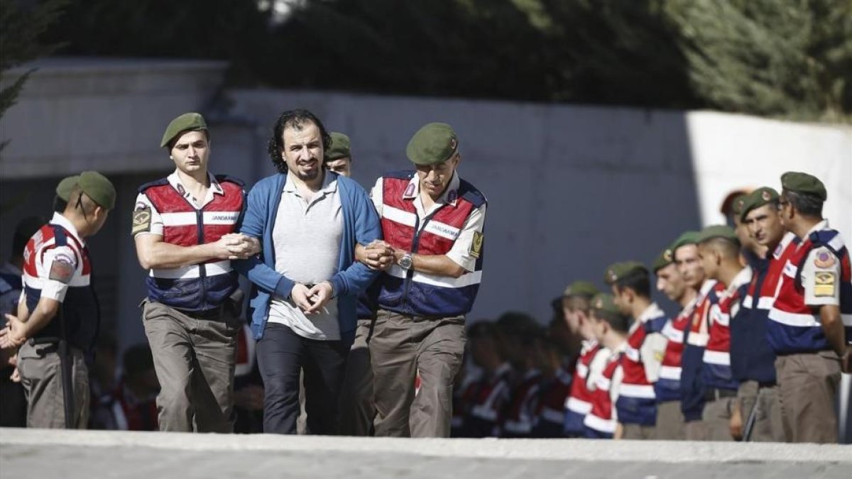 Soldados turcos escoltan a los 47 acusados de planificar el asesinato de Erdogan, antes de su juicio en Mungla (Turquía), el 4 de octubre-EFE / MUSTAFA CIFTCI