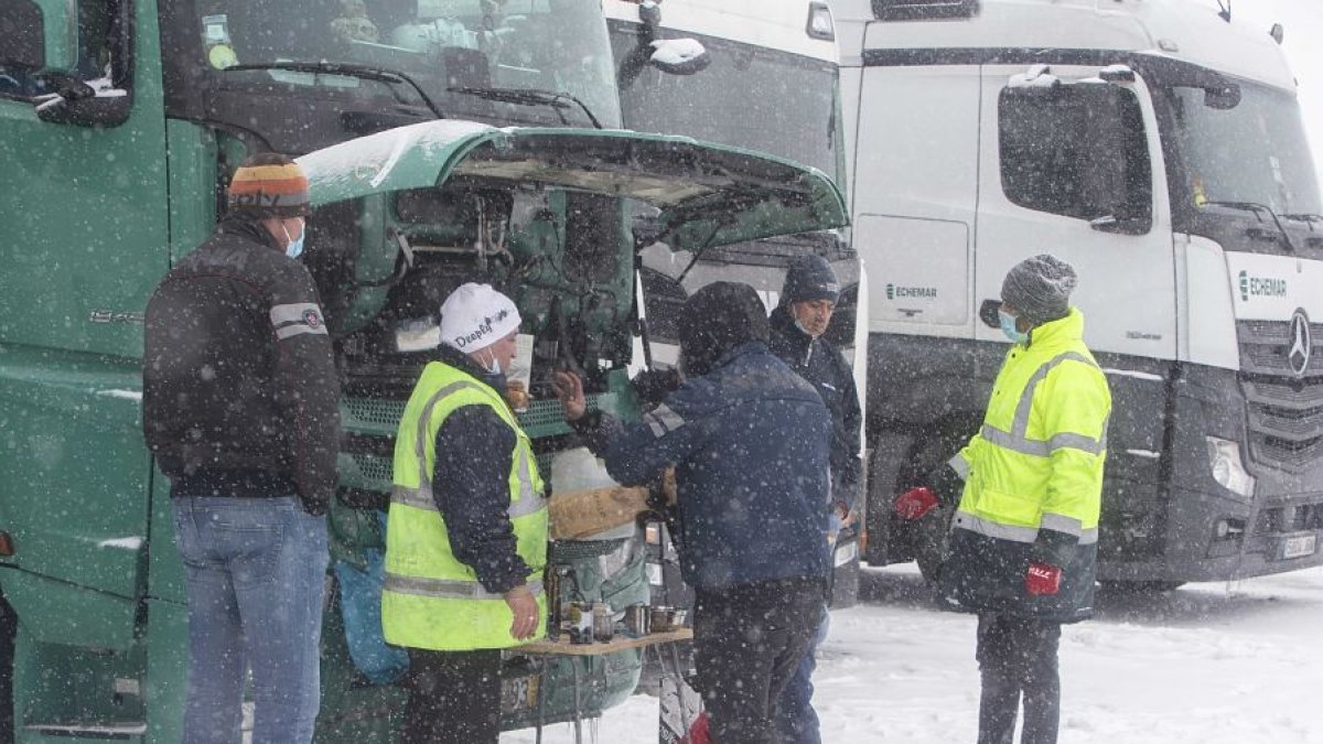 Transportistas se calientan junto al motor de un camión retenido en Rubena. RAÚL OCHOA