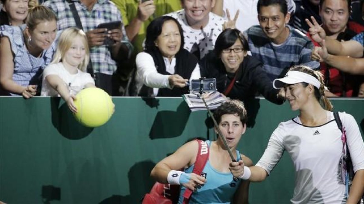 Garbiñe Muguruza y Carla Suárez celebrando su victoria junto a los aficionados presentes en Singapur-REUTERS / JEREMY LEE
