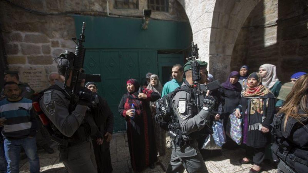 Agentes de policía israelís caminan junto a un grupo de mujeres palestinas en Jerusalén.-APC (EFE / ATEF SAFADI)