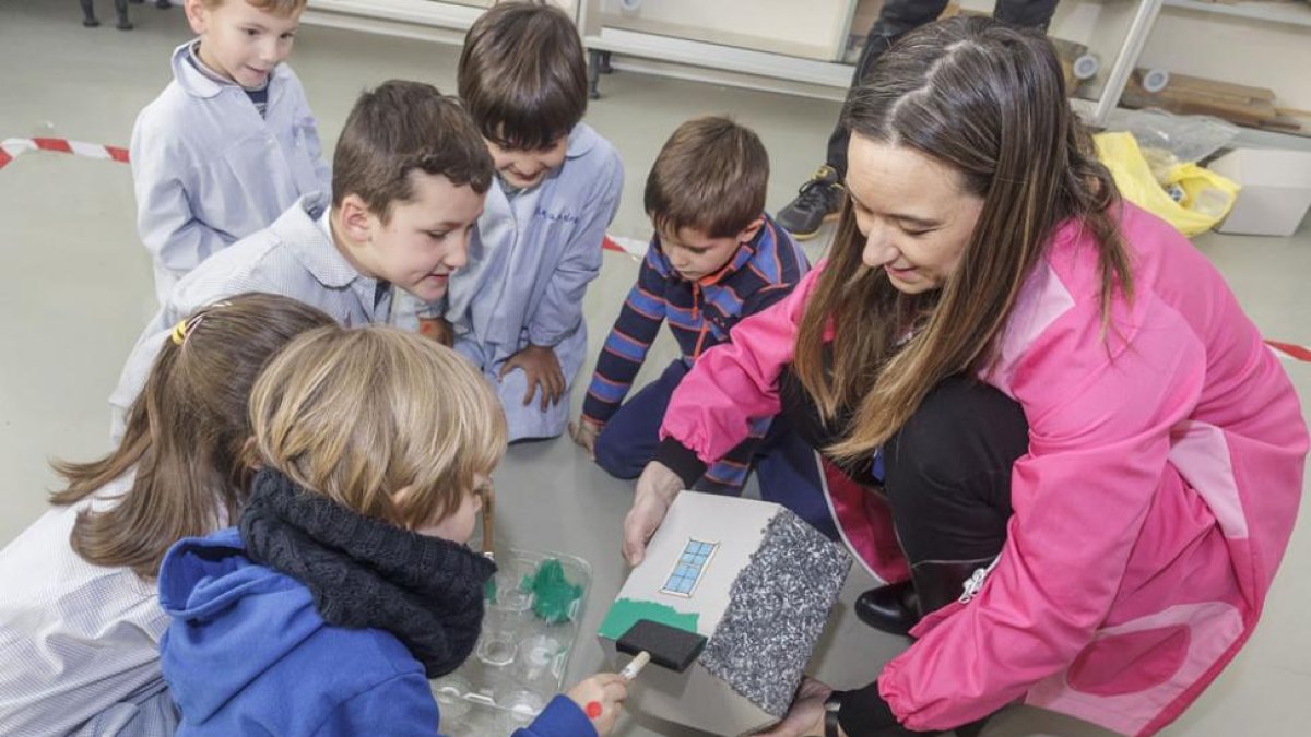 Varios niños realizan la maqueta de una casita con la ayuda de una profesora.-SANTI OTERO