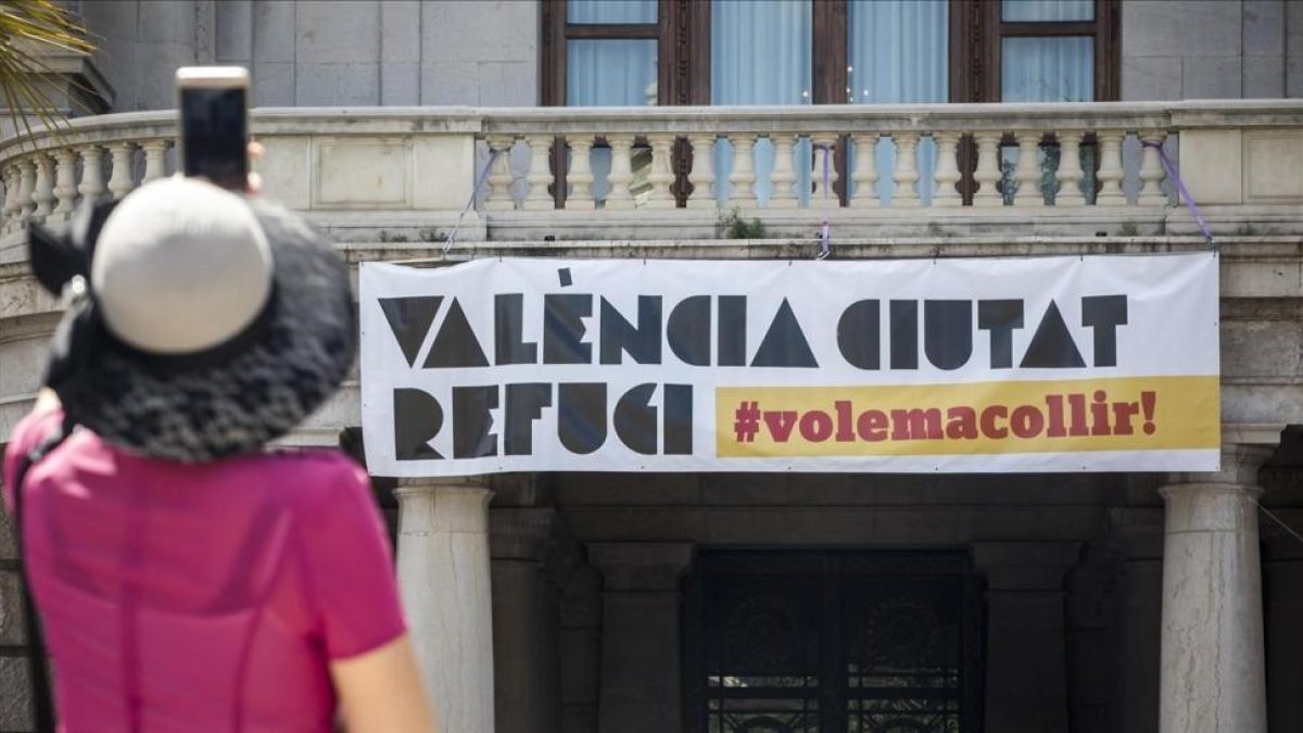 El Ayuntamiento de València ha vuelto a desplegar una pancarta que reivindica a la ciudad como refugio-/ MIGUEL LORENZO