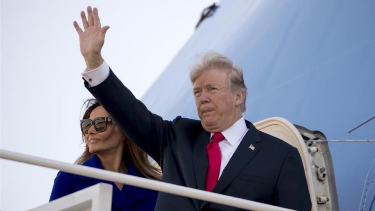 Trump y Melania Trump antes de abordar el Air Force One para iniciar su largo periplo por Asia.-AP / ANDREW HARNIK