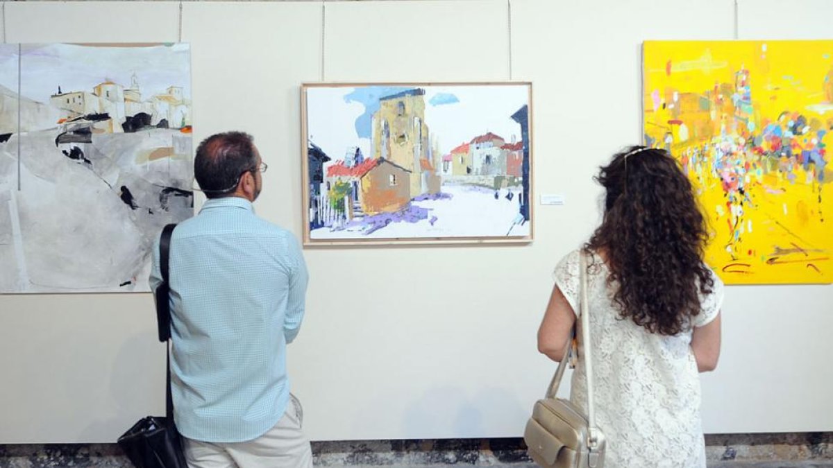 Dos visitantes observan la obra de Saiz Manrique (c.), flanqueada por la de María Jesús Mata (i.), la ganadora, y Susana Villar.-Israel L. Murillo