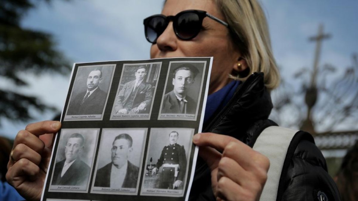 Una mujer sostiene una foto de sus familiares desaparecidos-JOSE LUIS ROCA