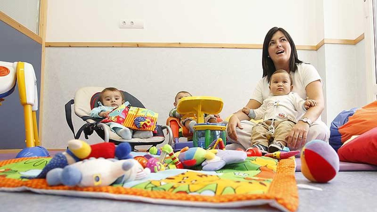 Tres bebés están con su monitora en la escuela infantil muncipal de Villalonquéjar.-RAÚL G. OCHOA