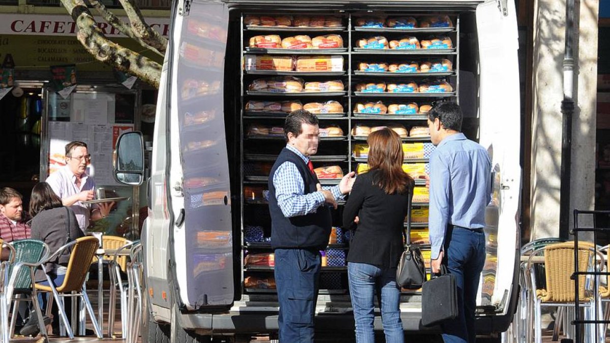 Un proveedor conversa con dos personas en la Plaza Mayor.-ISRAEL L. MURILLO