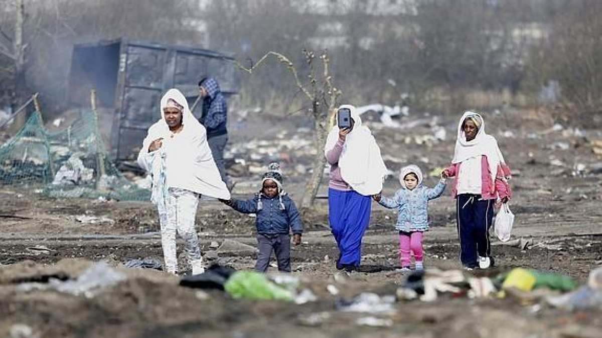 Refugiadas caminan con sus hijos por el campamento de Calais durante su desmantelamiento.-EFE / ARCHIVO