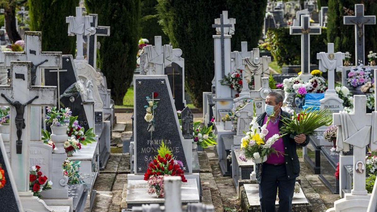 Una mujer camina entre las lápidas del cementerio. ECB