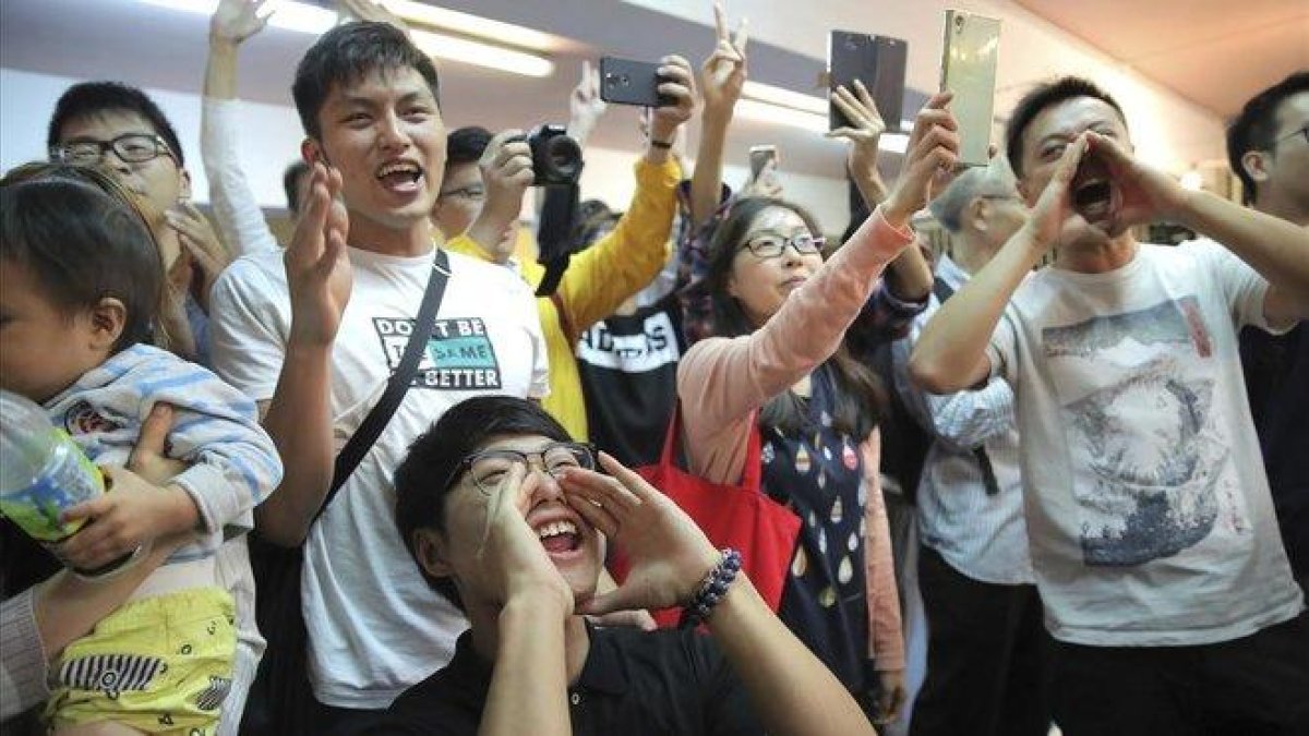 Jóvenes antigubernamentales celebran el resultado de las elecciones en Hong Kong, este domingo.-KIN CHEUNG (AP)