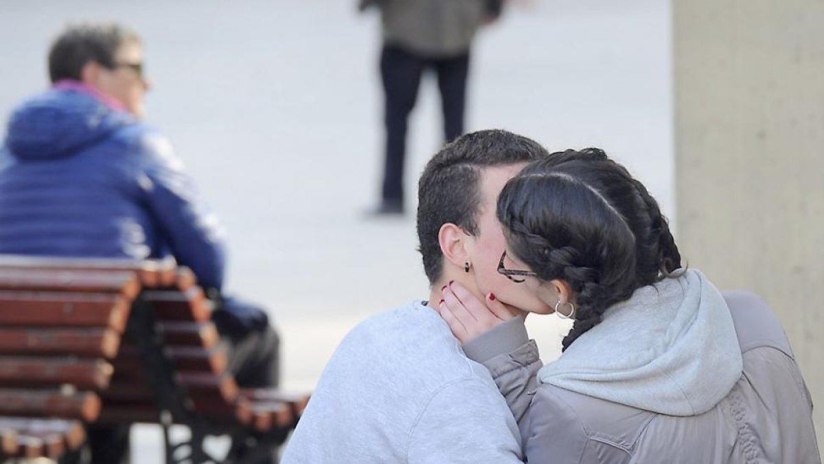 Dos jóvenes en un banco en un parque de la capital burgalesa.-ISRAEL L. MURILLO