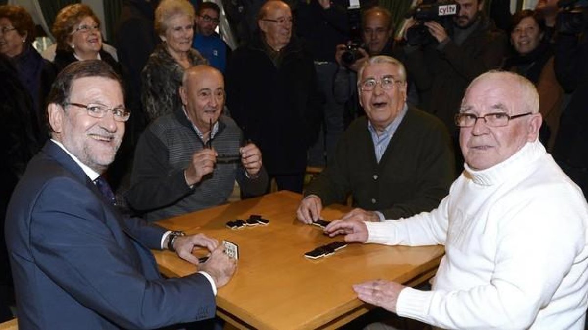 El presidente del Gobierno, Mariano Rajoy, junto a sus compañeros de juego en el Hogar del Pensionista, tras su intervención hoy en un mitin en la localidad vallisoletana de Olmedo.-EFE/Nacho Gallego