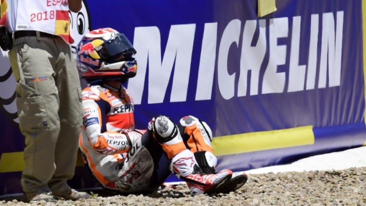 Dani Pedrosa (Honda), muy dolorido, espera la llegada de las asistencias tras el accidente con Andrea Dovizioso y Jorge Lorenzo.-/ AFP / JAVIER SORIANO