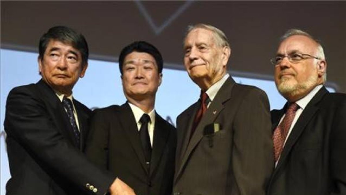 El asesor especial del primer ministro de Japón y el representante de Mitsubishi Motors se estrechan la mano con James Murphy, exprisionero de guerra estadounidense, durante el acto que tuvo lugar el domingo en Los Angeles.-Foto: AP / DAMIAN DOVARGANES
