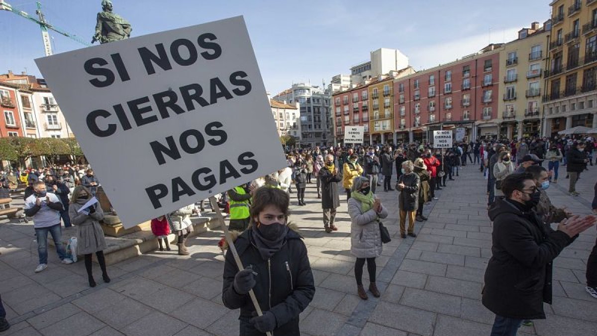 Una persona sostiene un cartel exigiendo compensaciones económicas durante una protesta contra los cierres de hostelería decretados por la Junta. S. OTERO