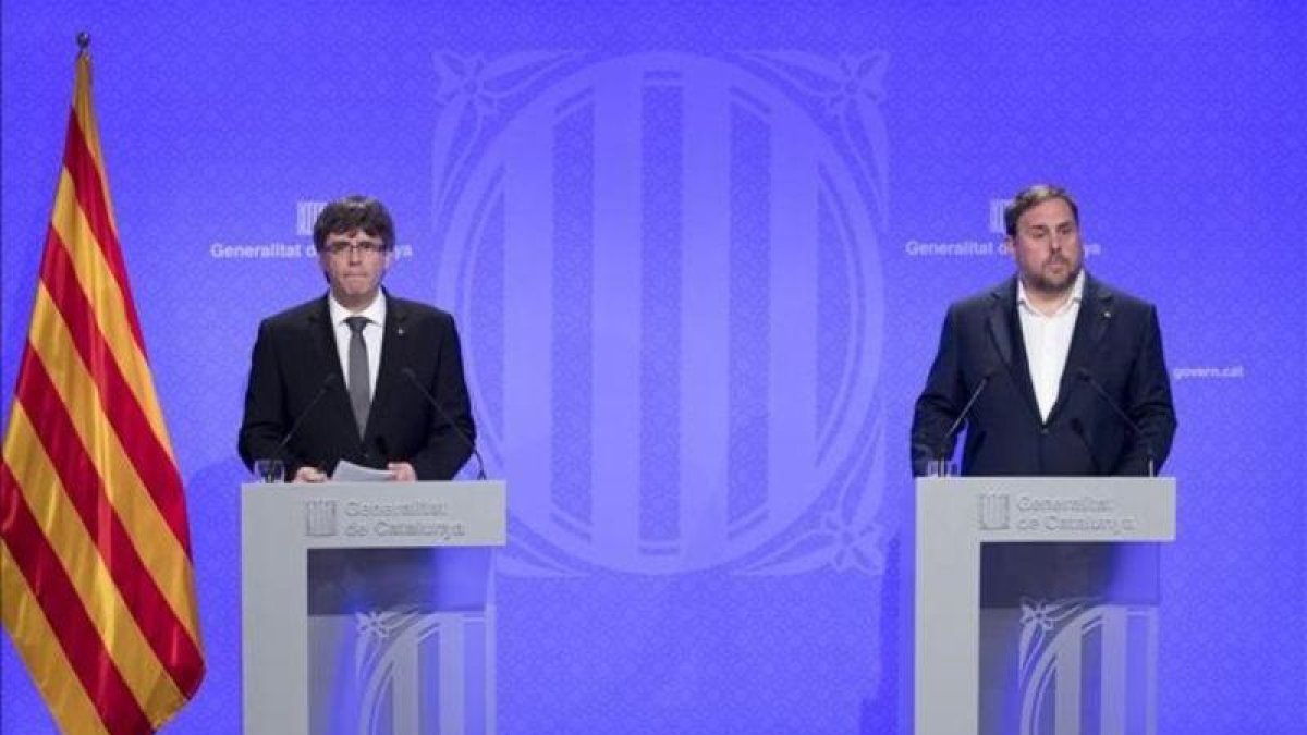 Carles Puigdemont y Oriol Junqueras, en la rueda de prensa en la que se anunciaron los últimos cambios en el Govern.-FERRAN NADEU