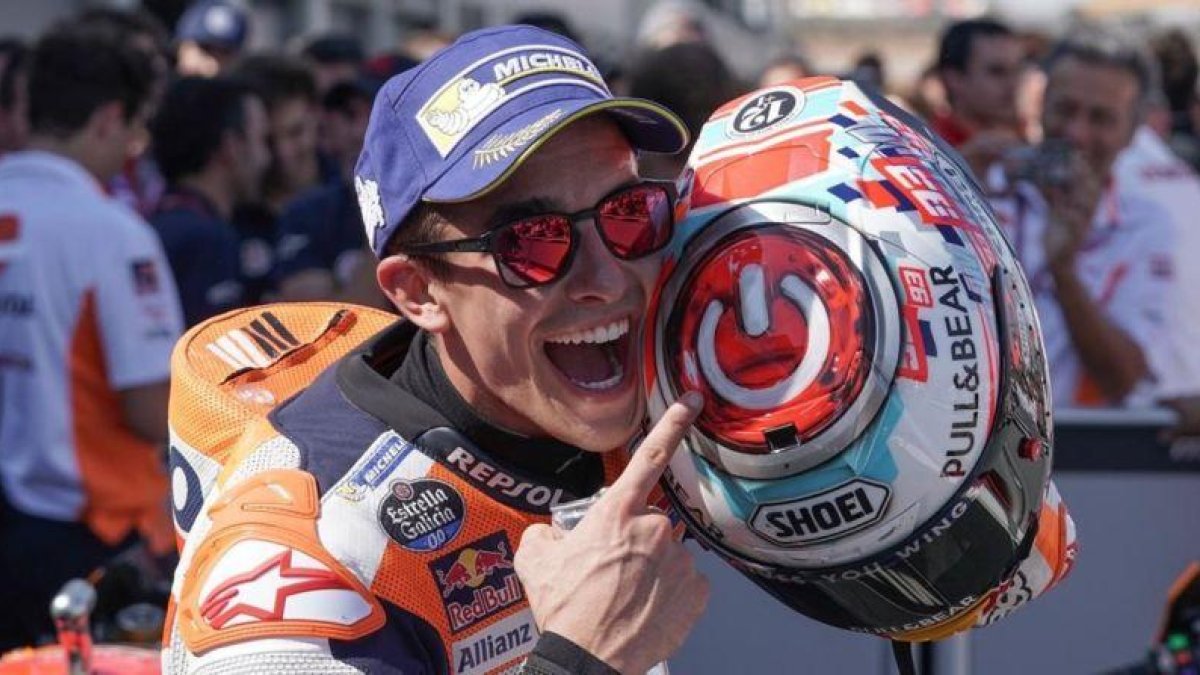 Marc Márquez señala, feliz, el interruptor que tiene dibujado sobre su casco.-ALEJANDRO CERESUELA