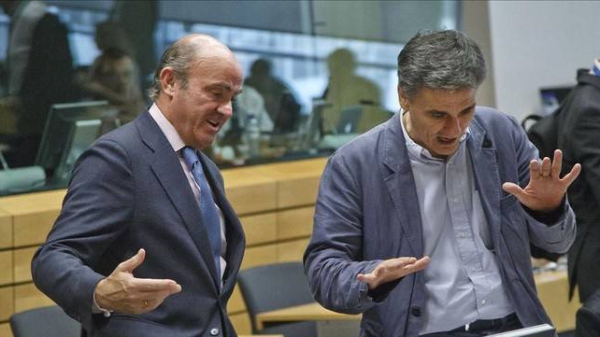 Guindos (izquierda) conversa con el nuevo ministro griego de Finanzas, Euclid Tsakalotos, este martes en Bruselas.-Foto: AP / MICHEL EULER