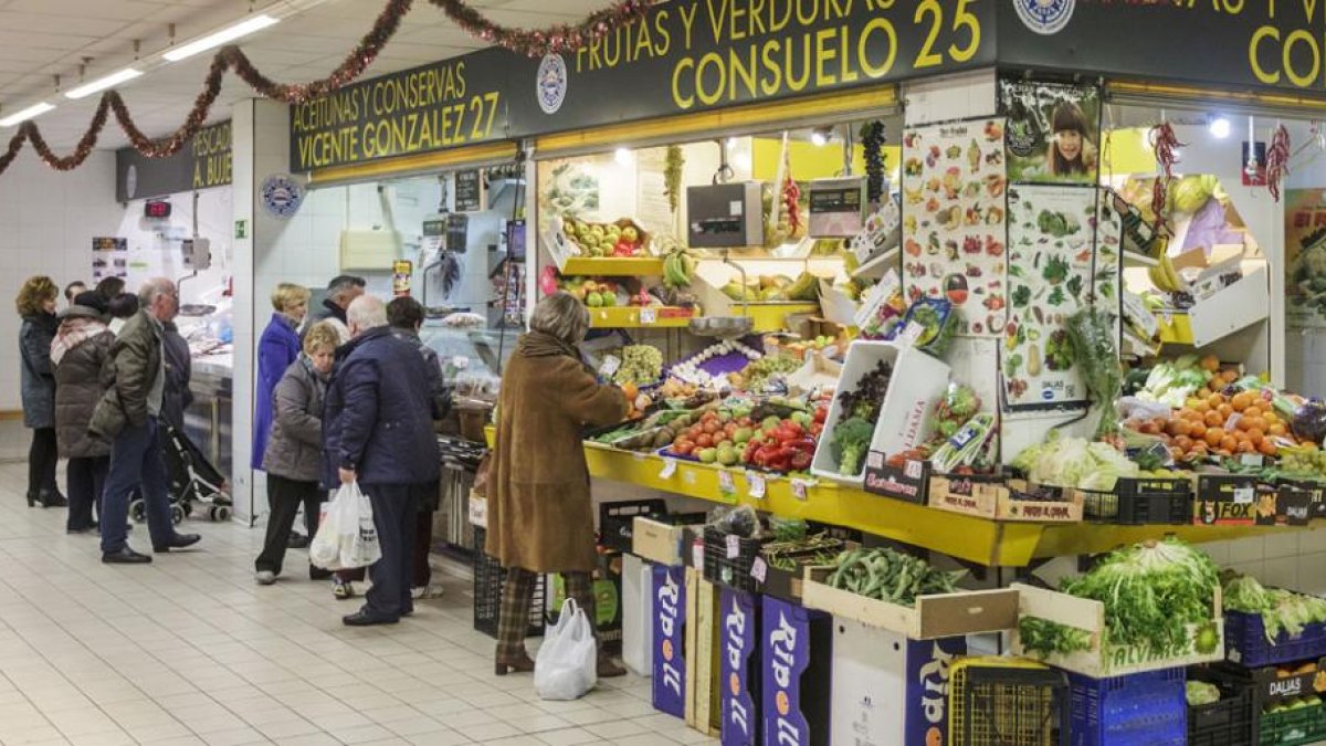 Varias personas realizan sus compras de alimentación en los puestos del Mercado Norte.-SANTI OTERO