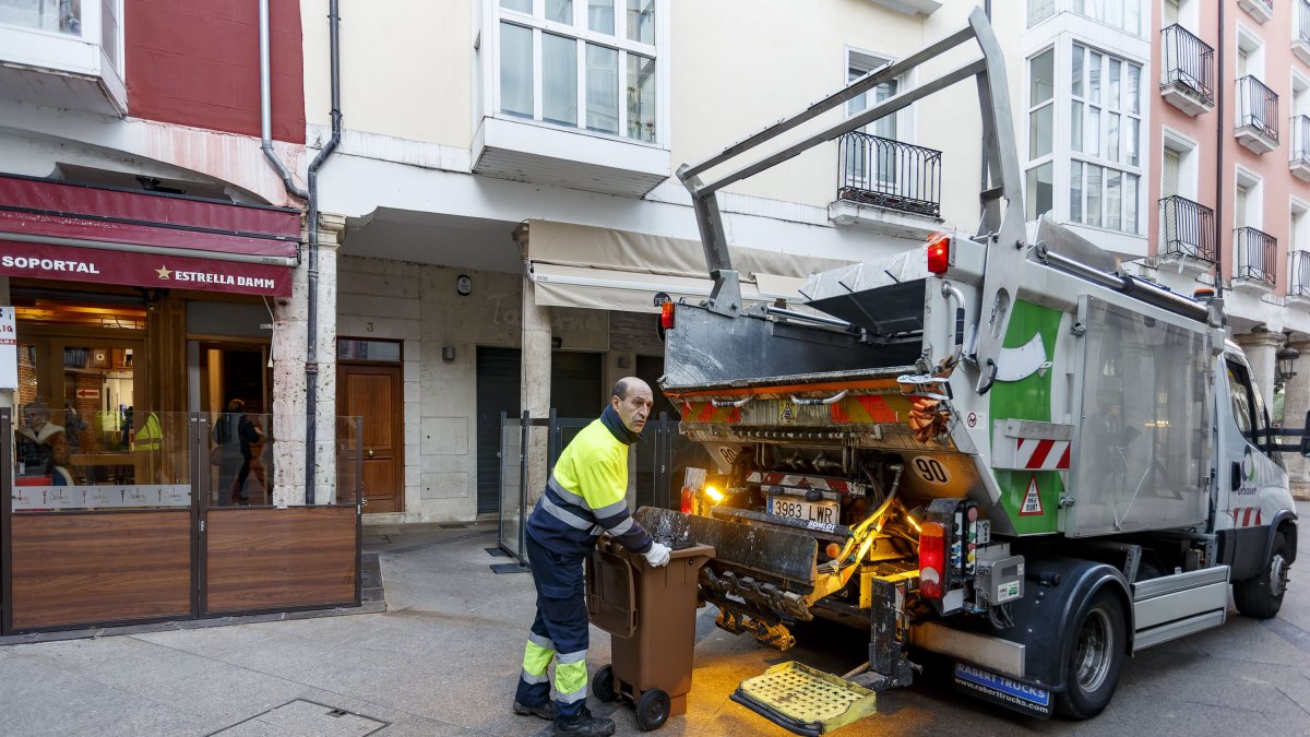 Un operario recoge un cubo de orgánico de un bar. SANTI OTERO