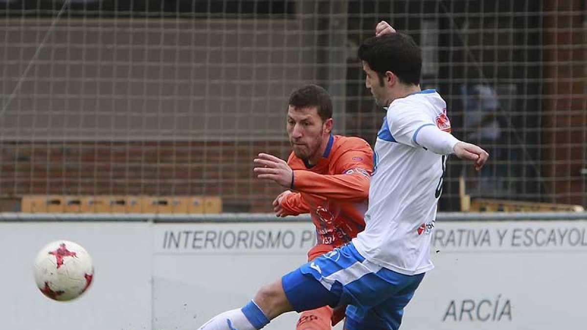Jairo golpea un balón ante un jugador del Almazán-Raúl G. Ochoa