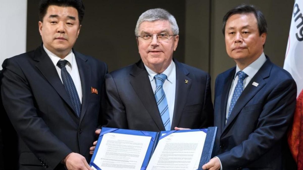 El presidente del COI, Thomas Bach, con los representantes de Corea del Norte (izquierda) y Corea del Sur con el acuerdo firmado en Lausana-AFP / FABRICE COFFRINI