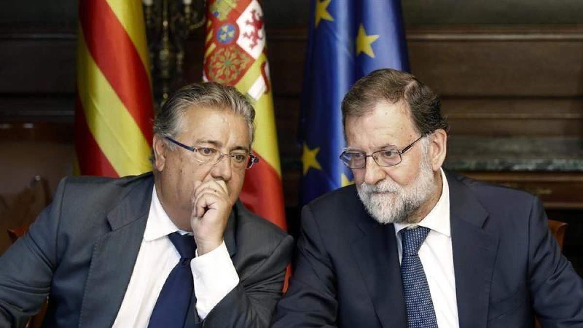 El jefe del Ejecutivo, Mariano Rajoy (d), y el ministro del Interior, Juan Ignacio Zoido (i), durante la reunión con responsables de las Fuerzas de Seguridad del Estado para analizar la situación tras los atentados en Barcelona y Cambrils.-EFE / ANDREU DALMAU