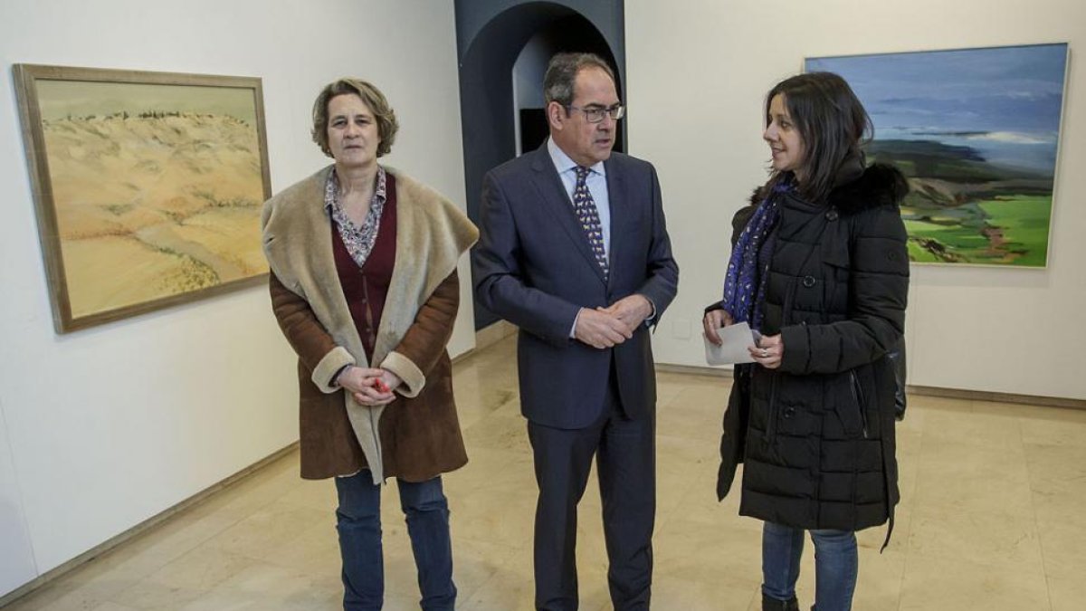 Marta Negro (i.), Baudilio Fernández Mardomingo y María Sanz Nieto, entre los óleos donados.-Santi Otero