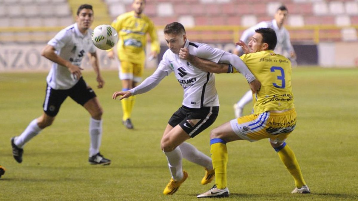 El defensa de la Arandina Garcés agarra de la camiseta a Fito Miranda, autor del segundo gol capitalino.-ISRAEL L. MURILLO