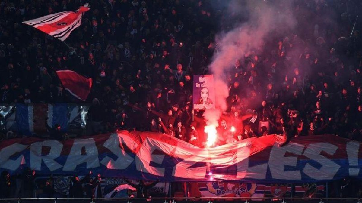 Aficionados del París SG encienden bengalas durante el partido de Copa ante el Olympique.-AFP / CHRISTOPHE SIMON