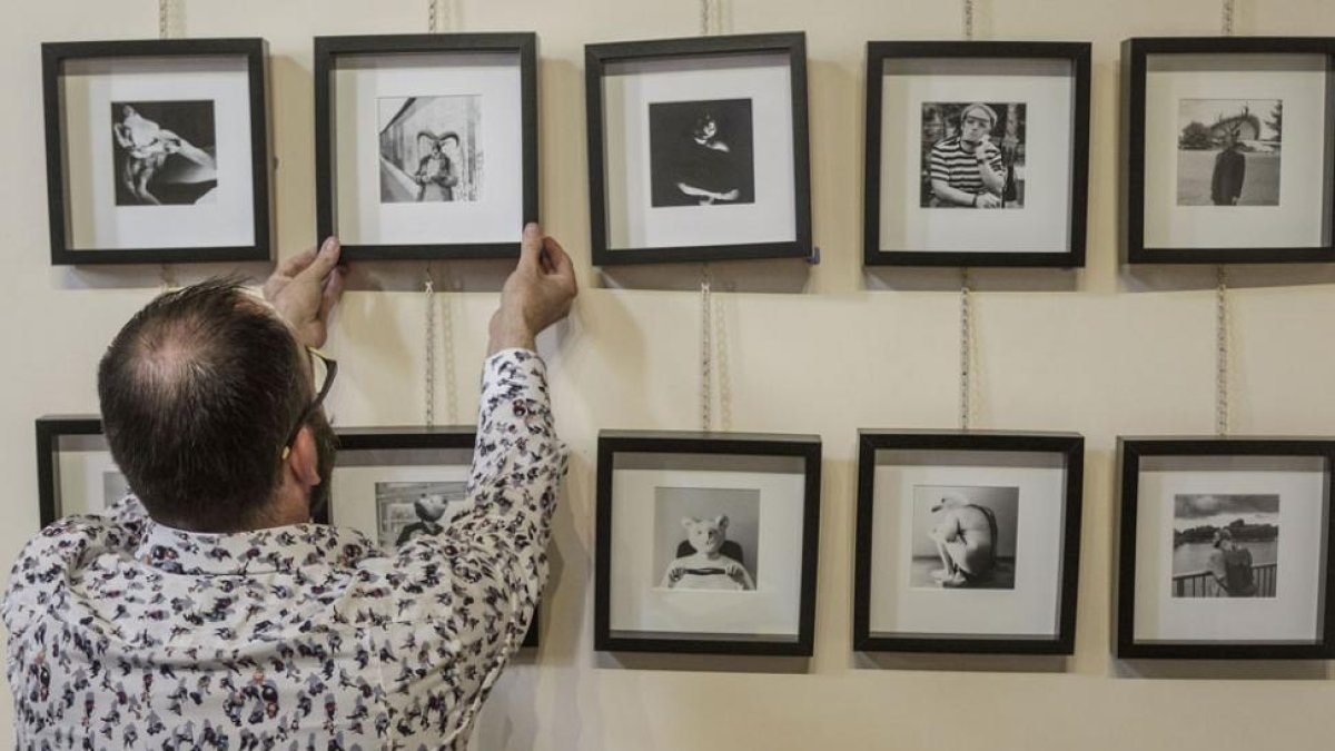 Uno de los artistas coloca su obras antes de la apertura de la feria.-SANTI OTERO