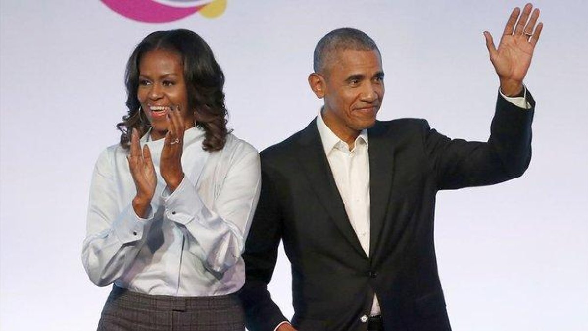 El matrimonio Obama posa sonriente tras firmar el acuerdo con con la plataforma de música en streaming Spotify.-AP / CHARLES REX