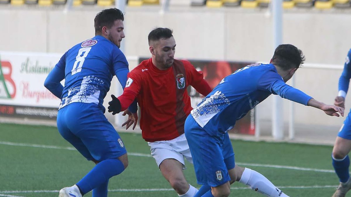 El lateral zurdo Diego (Real Burgos) regatea a dos contrarios del Real Ávila durante la primera mitad-RAÚL G. OCHOA