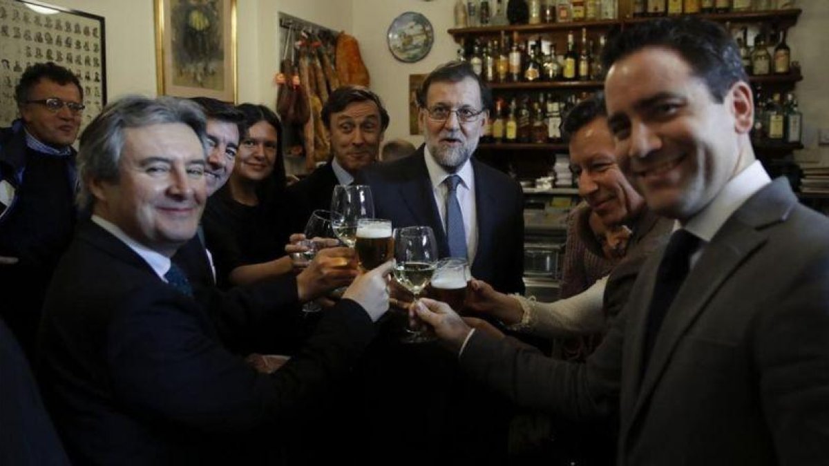 Mariano Rajoy, acompañado de varios diputados del PP, este jueves, celebrando la Navidad en un bar próximo al Congreso.-EFE / JUAN CARLOS HIDALGO