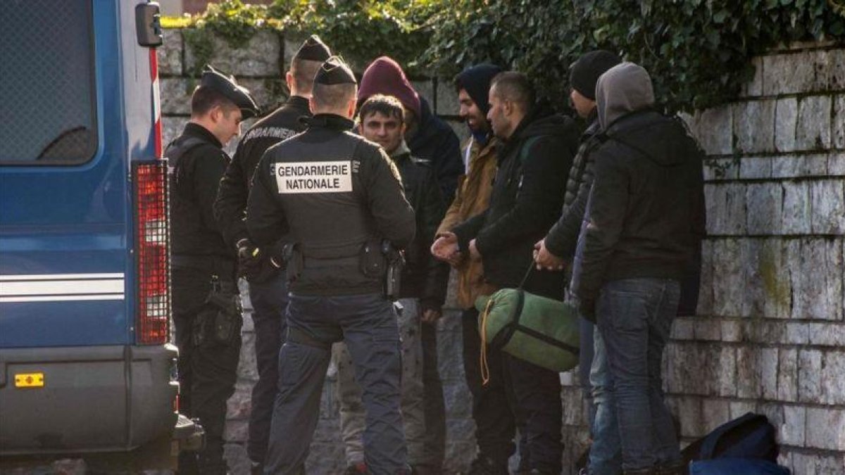 La policía francesa intercepta a un grupo de refugiados que intentan entrar en el Reino Unido por el paso de Calais.-AFP / PHILIPPE HUGUEN