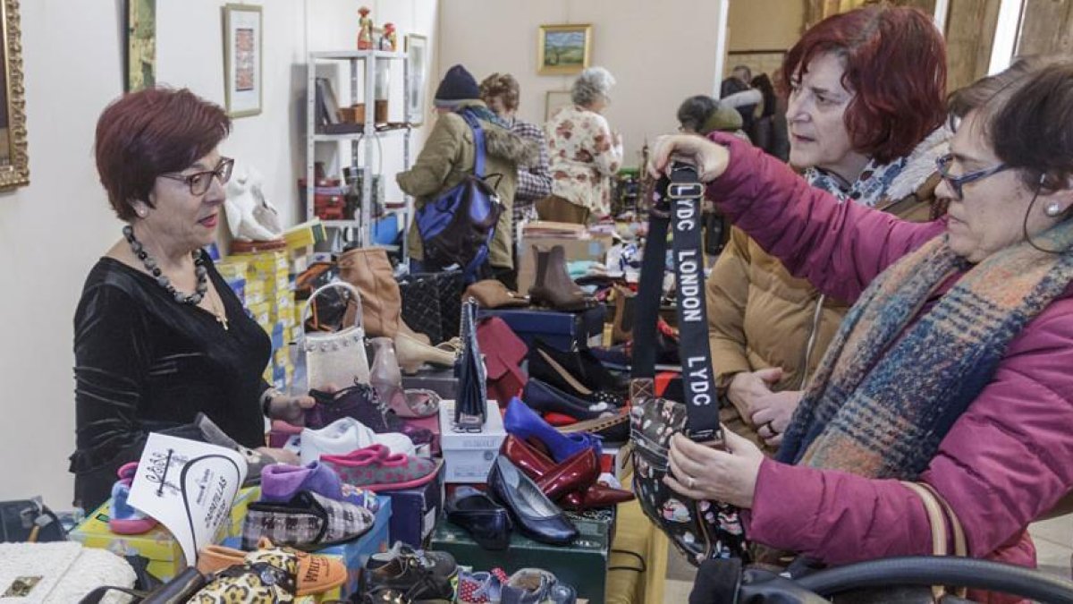 Dos mujeres preguntan por un bolso en uno de los puestos del mercadillo solidario.-SANTI OTERO