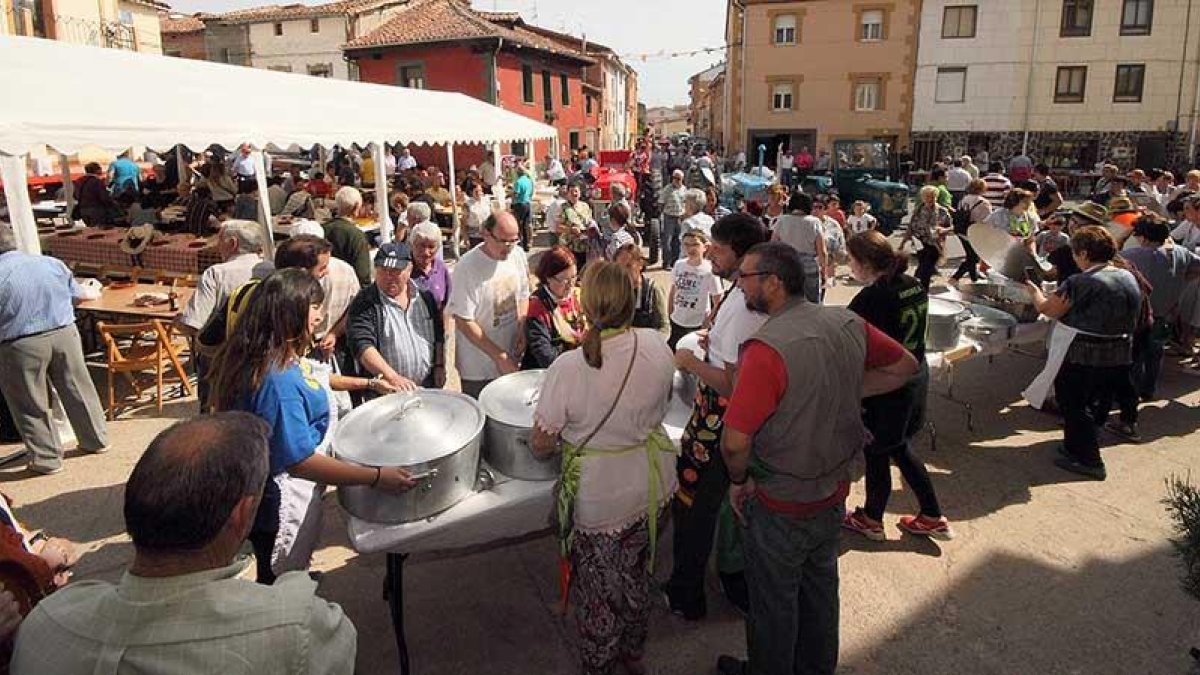 Un grupo de comensales espera a que las ollas se abran para recibir su correspondiente ración.-G.G.