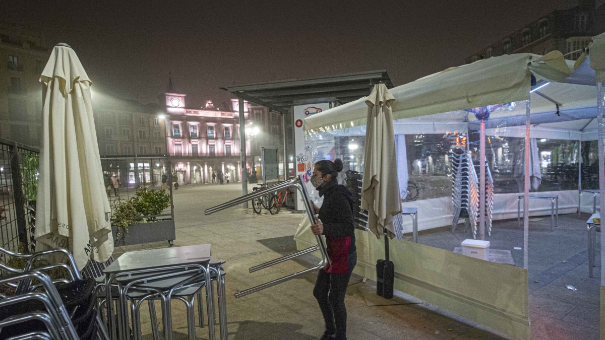 Recogida de una terraza minutos antes del toque de queda. ISRAEL L. MURILLO