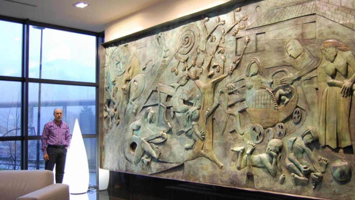 Javier Sanz junto a uno de sus grandes encargos. Un mural en bronce para el hotel Gran Bilbao en 2008.-ART-TERRA