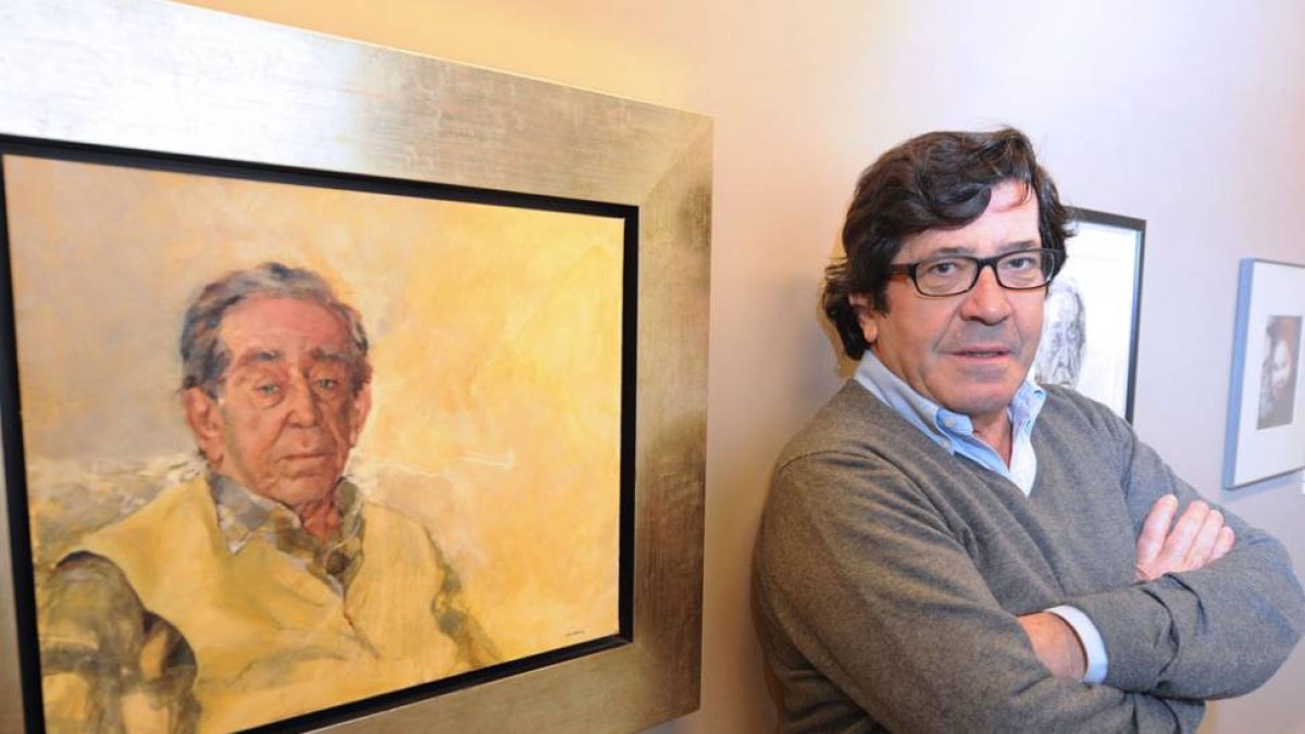 El artista posando con uno de sus retratos.-Israel L. Murillo