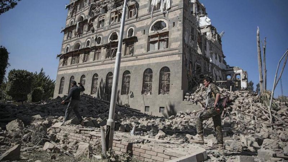 Dos rebeldes yemeníes inspeccionan las ruinas de edificios destruidos por los bombardeos en Saná.-HANI MOHAMMED (AP)