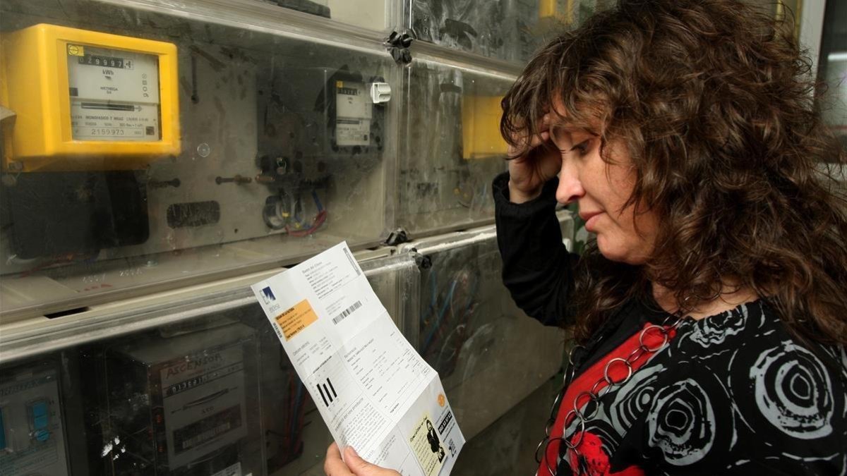 Una mujer consulta una factura eléctrica.